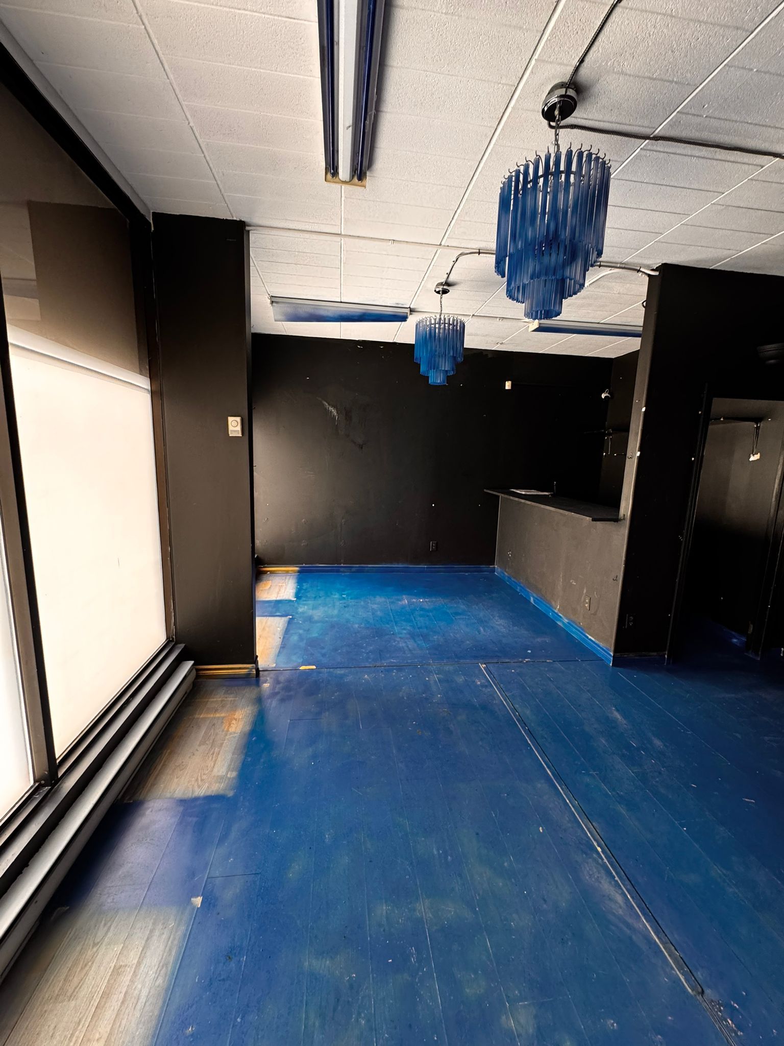 Main commercial floor with blue pendant chandeliers and bar counter