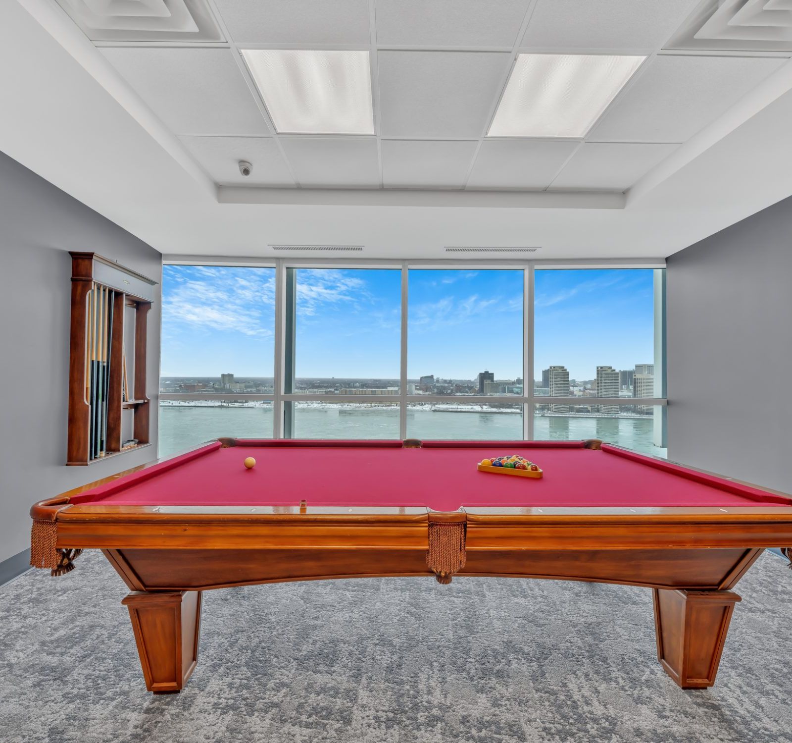 Pool table with floor-to-ceiling window and city water view
