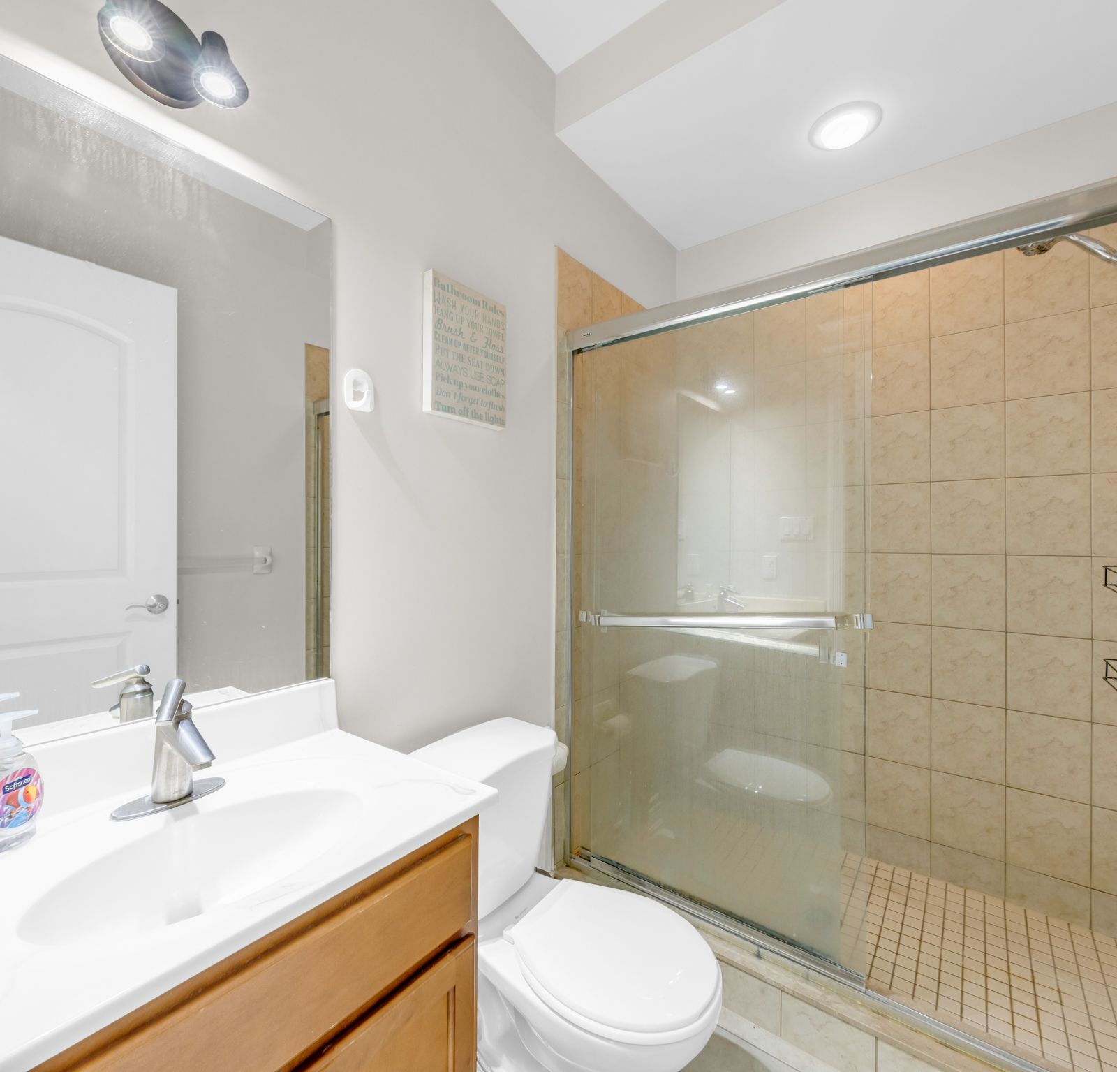 Bathroom with glass sliding shower door and tiled walls