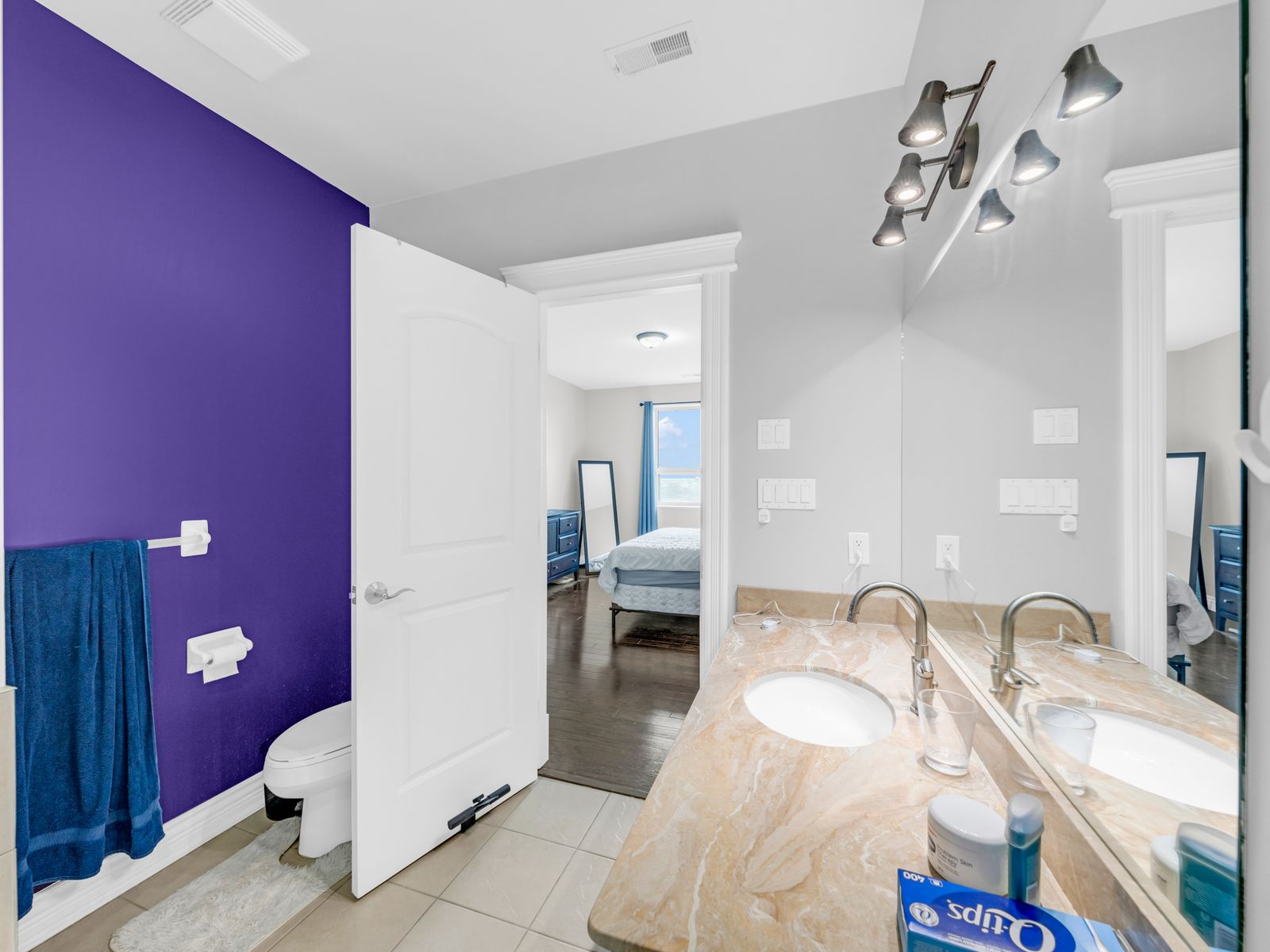 Second bathroom with purple accent wall and marble vanity