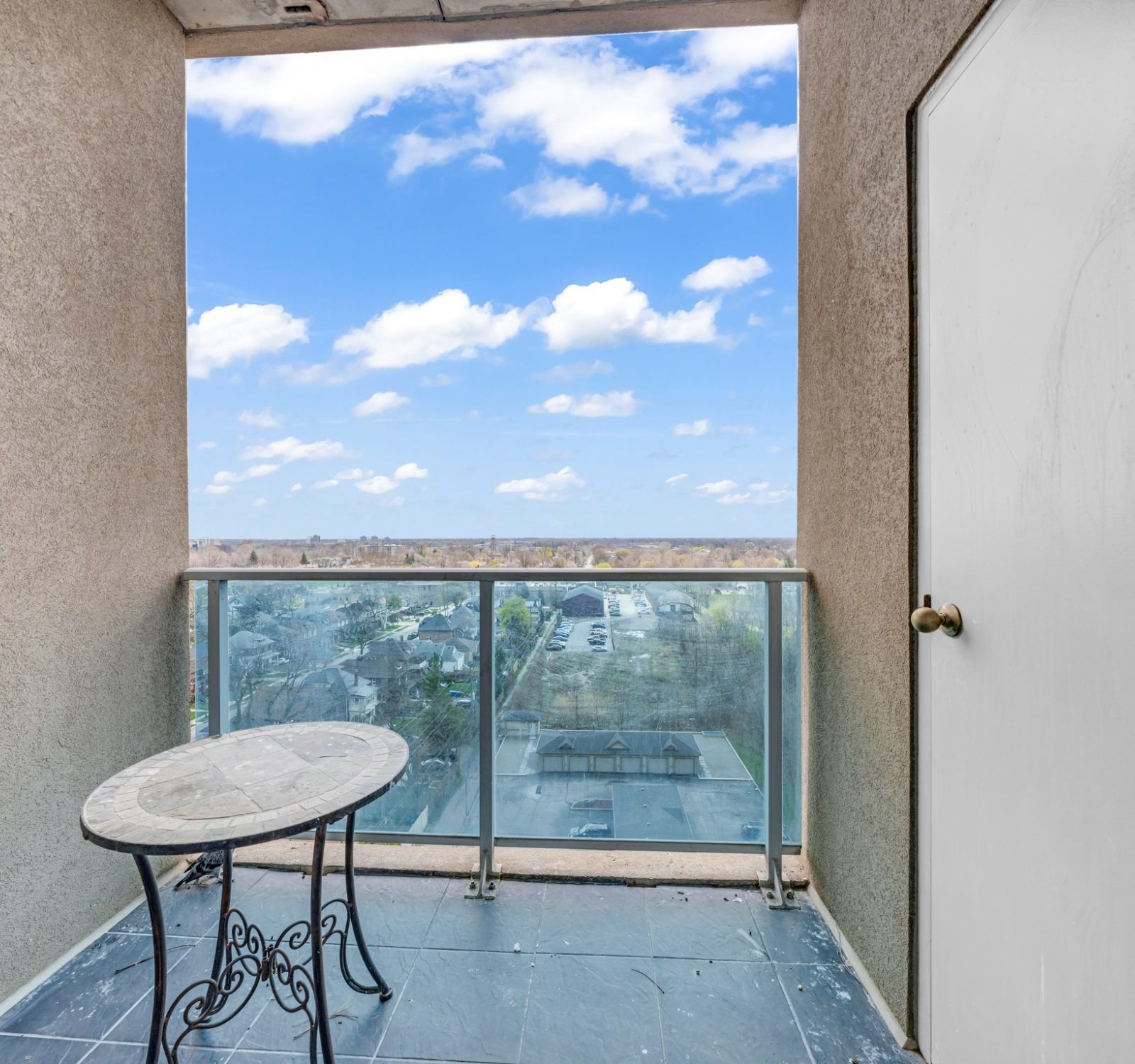 Private balcony with glass railing and neighbourhood view