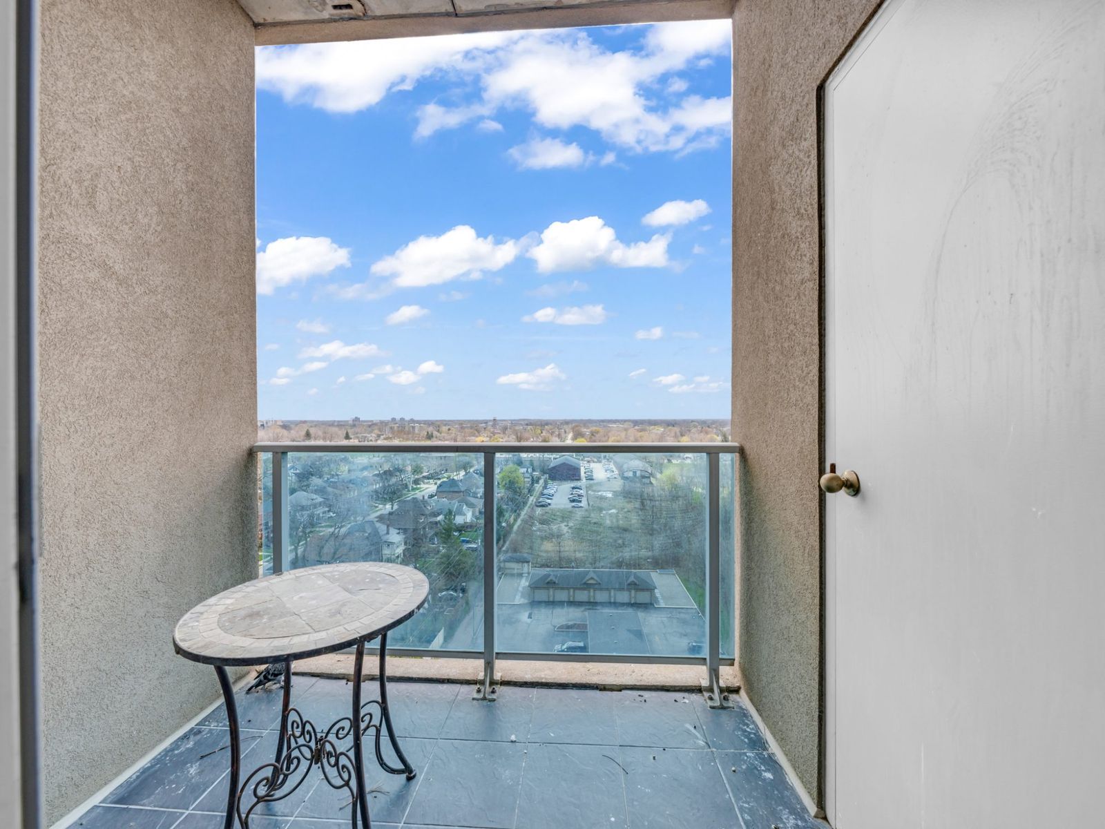 Private balcony with glass railing and neighbourhood view