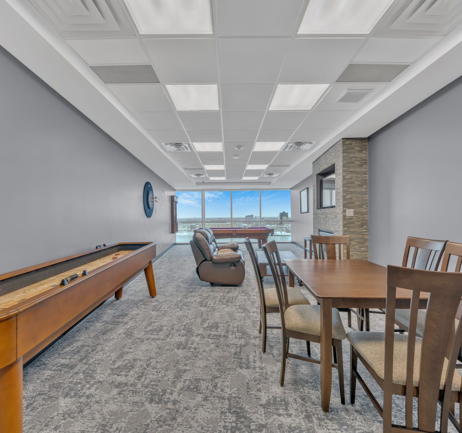 Games lounge with shuffleboard, pool table, and city view