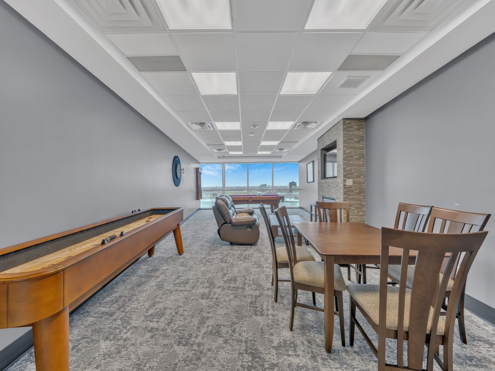 Games lounge with shuffleboard, pool table, and city view