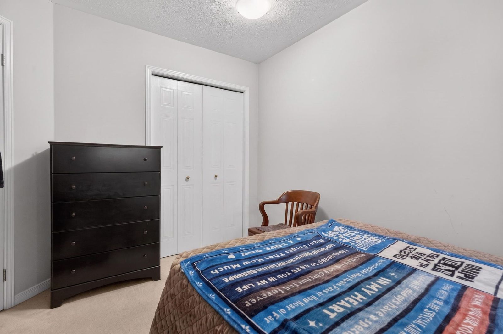 Bedroom with double closet doors and chest of drawers