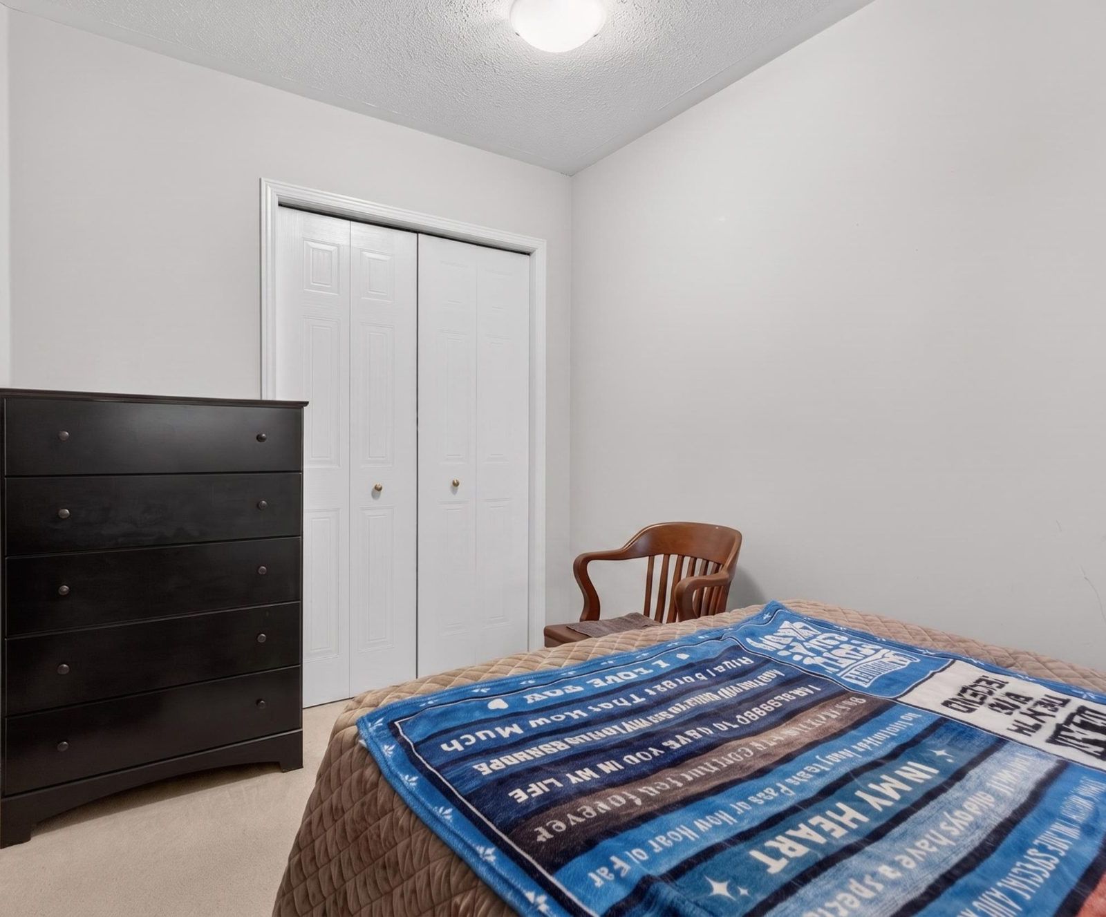 Bedroom with double closet doors and chest of drawers