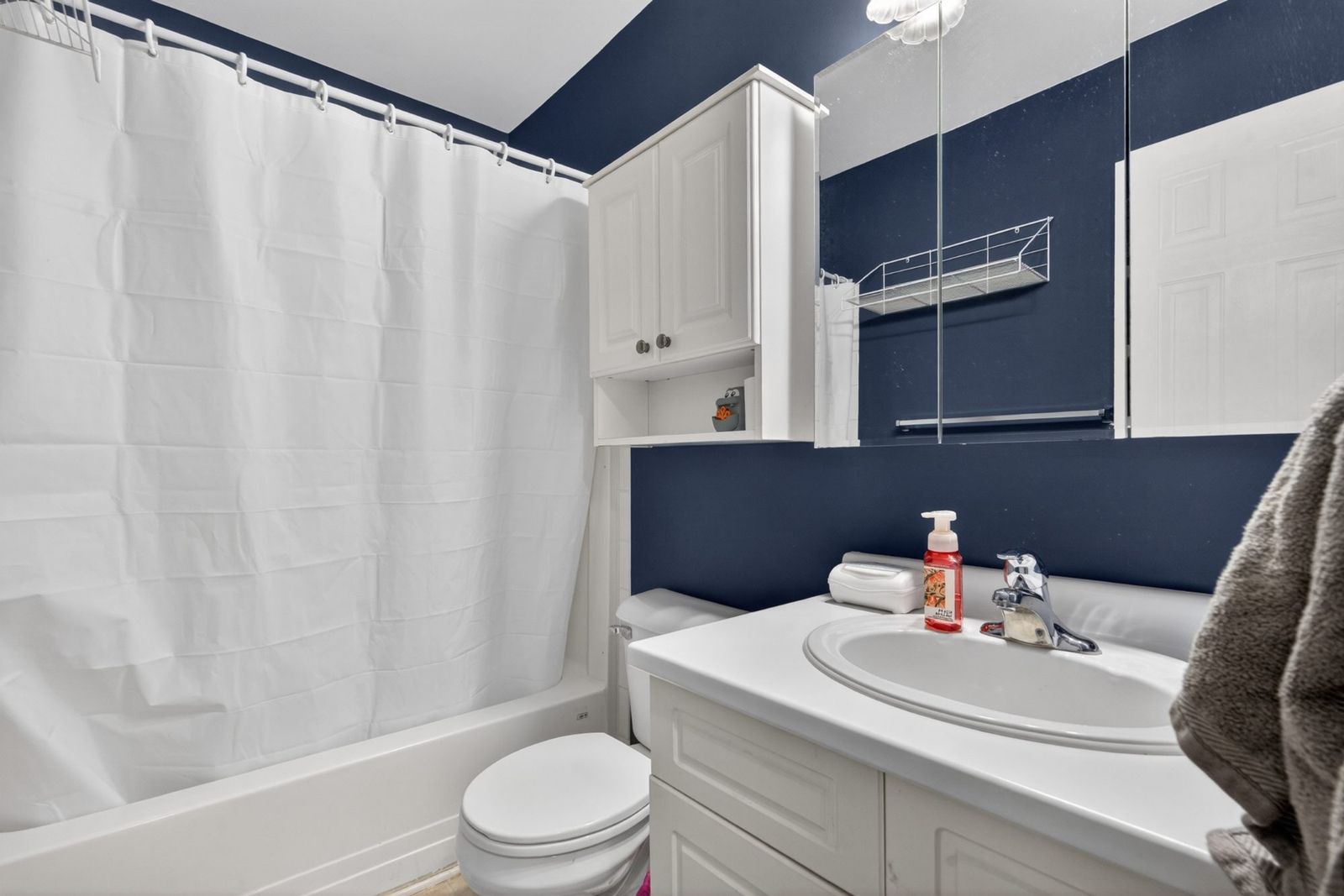 Bathroom with white bathtub and navy blue walls