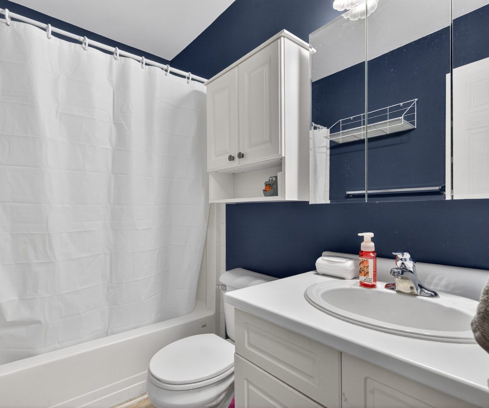 Bathroom with white bathtub and navy blue walls