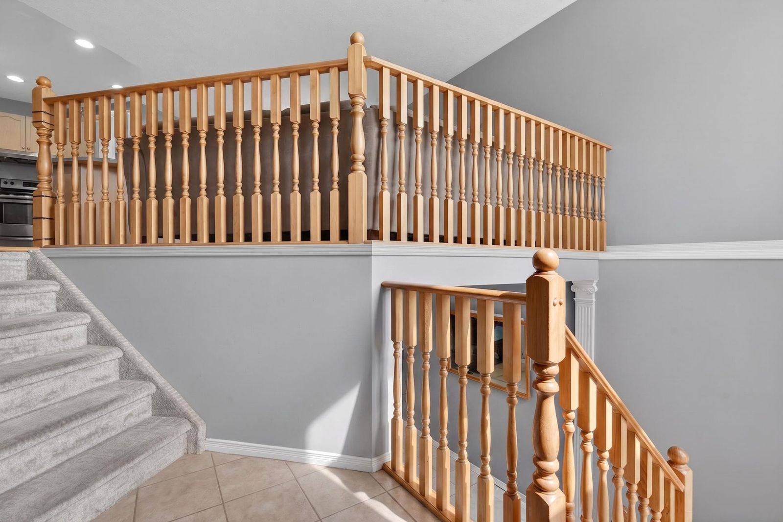 Carpeted staircase with wooden railing