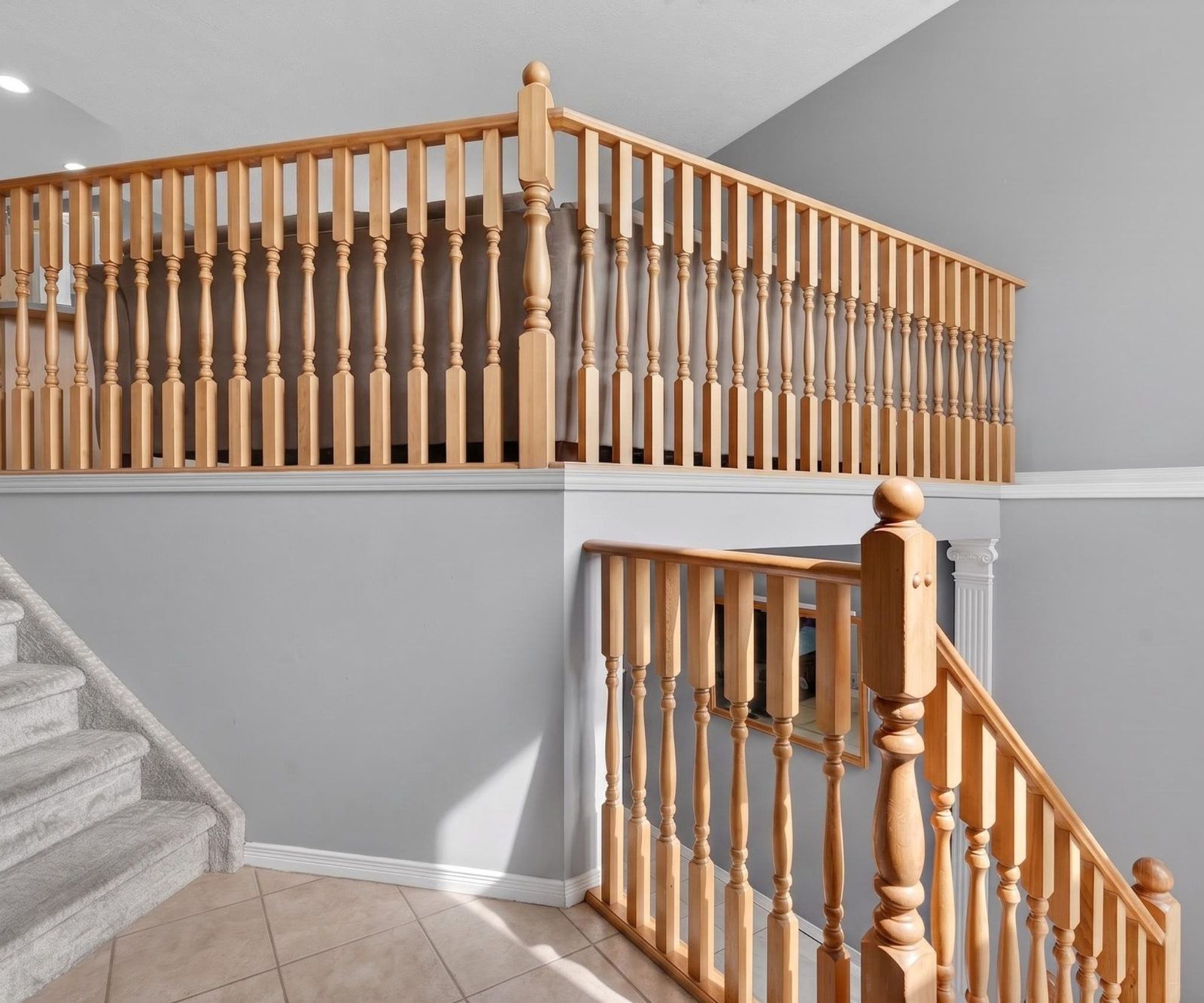 Carpeted staircase with wooden railing