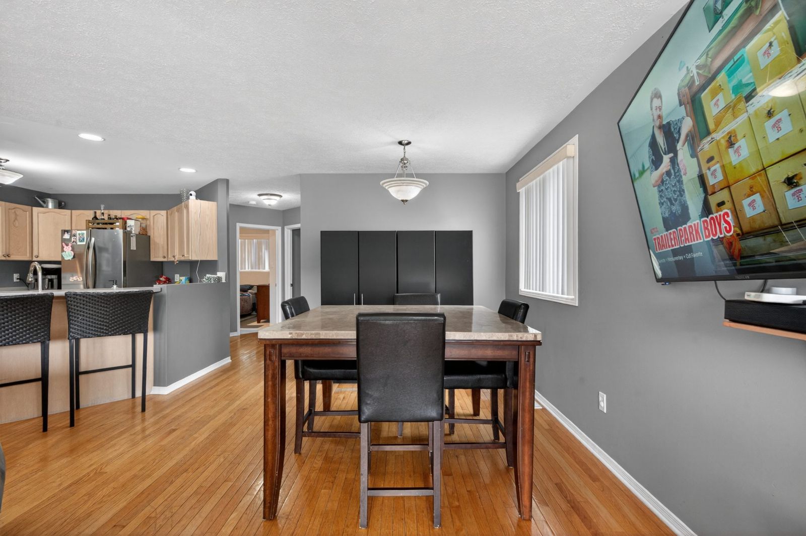 Dining area with table, breakfast bar visible, and hardwood floors