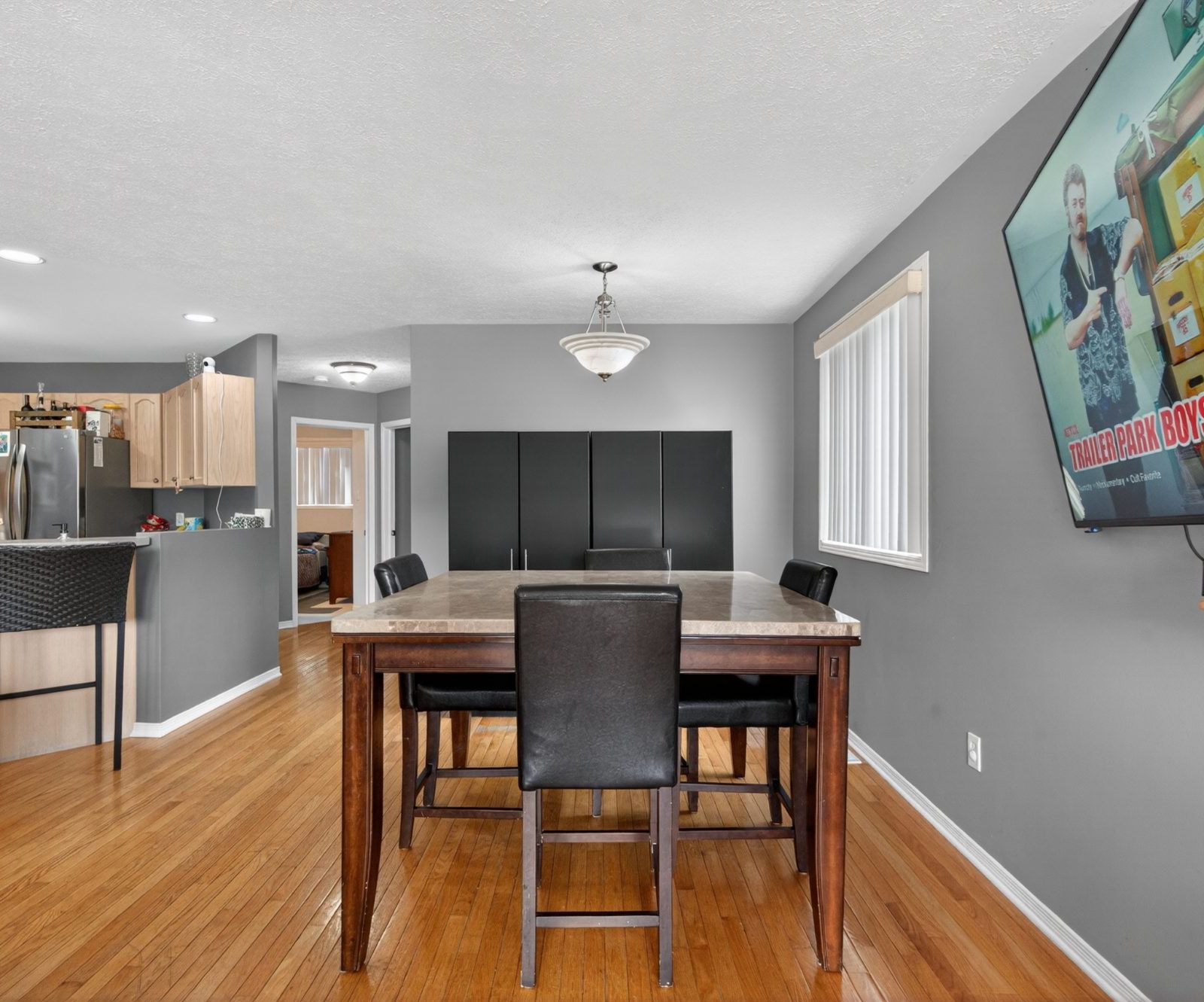 Dining area with table, breakfast bar visible, and hardwood floors