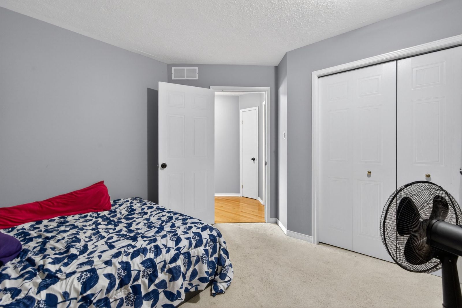 Bedroom with double closet doors and carpeted floor