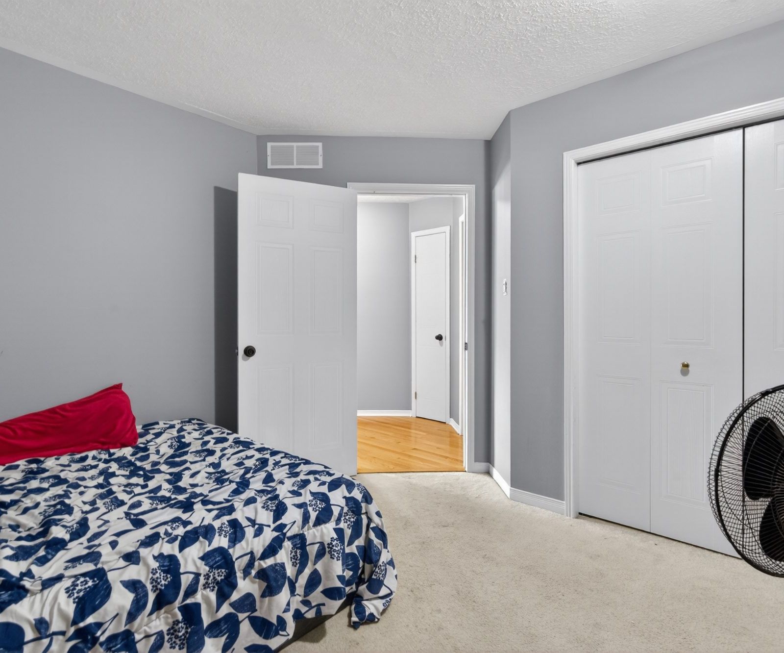 Bedroom with double closet doors and carpeted floor