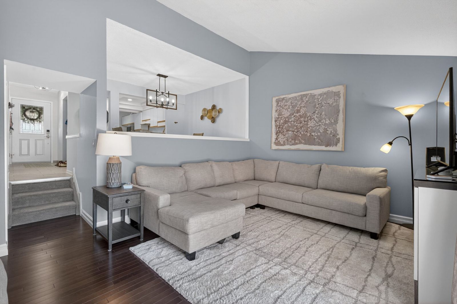Living room with interior cutout window and stair opening