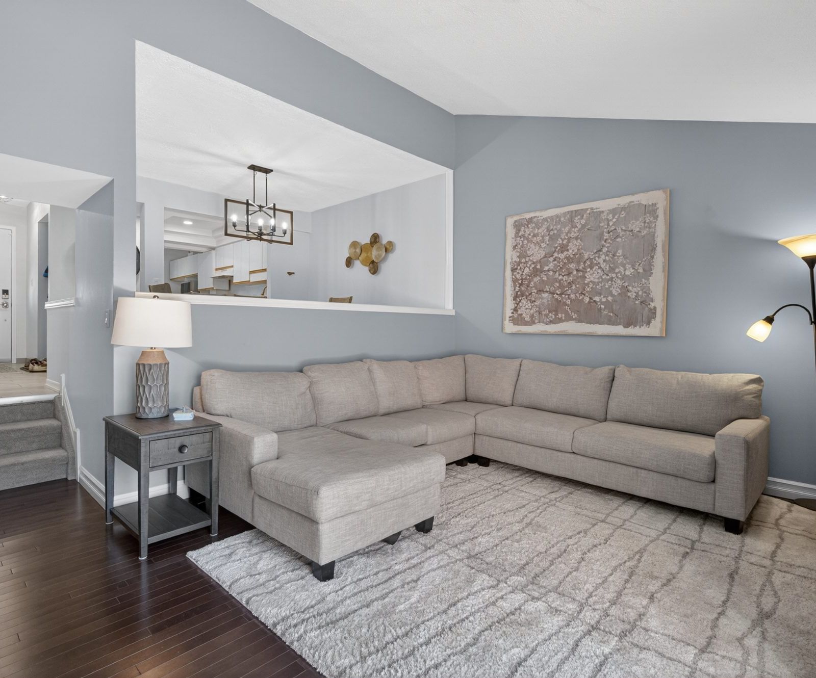 Living room with interior cutout window and stair opening