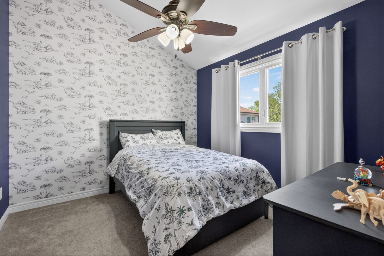 Bedroom with ceiling fan and accent wall