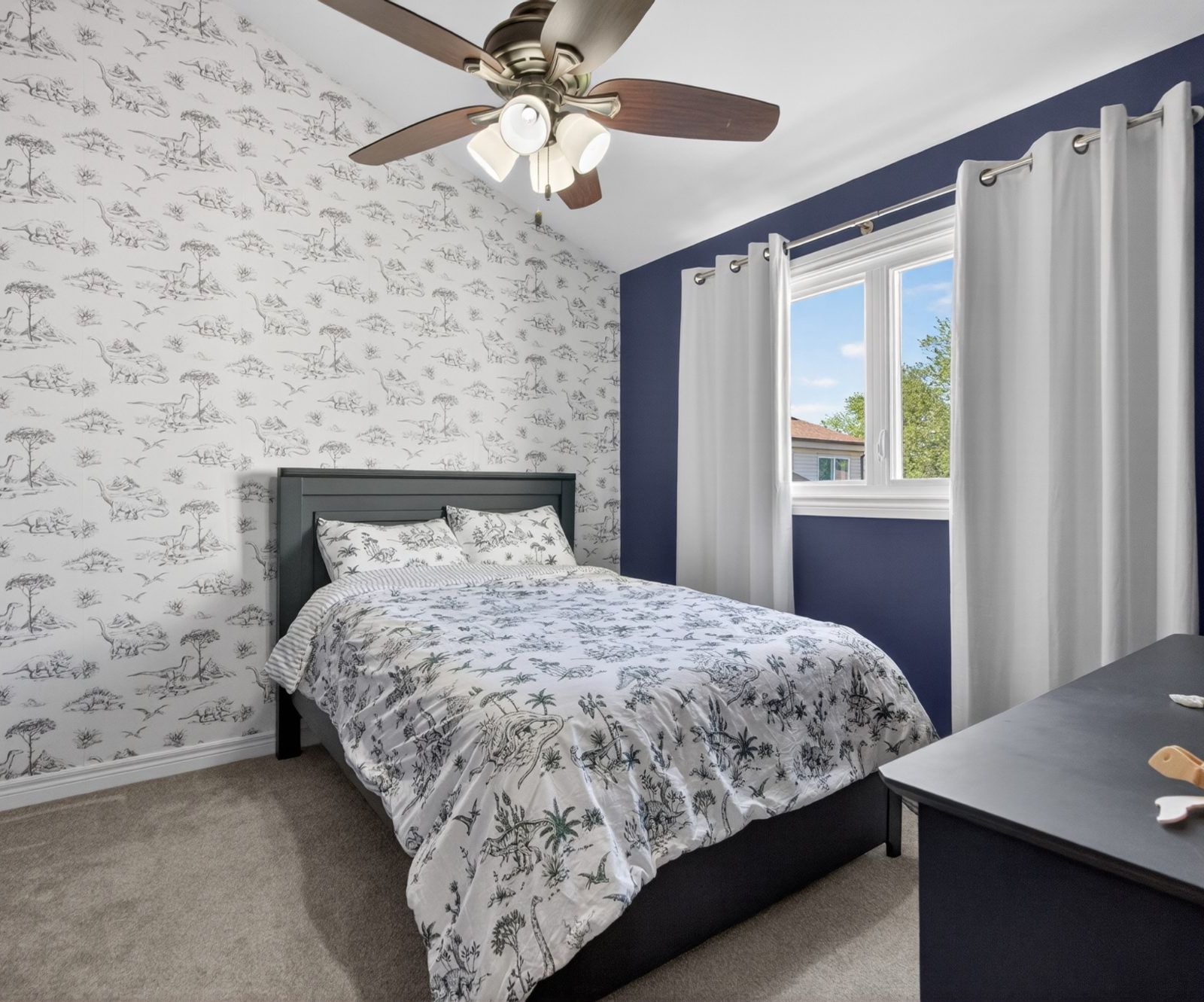 Bedroom with ceiling fan and accent wall