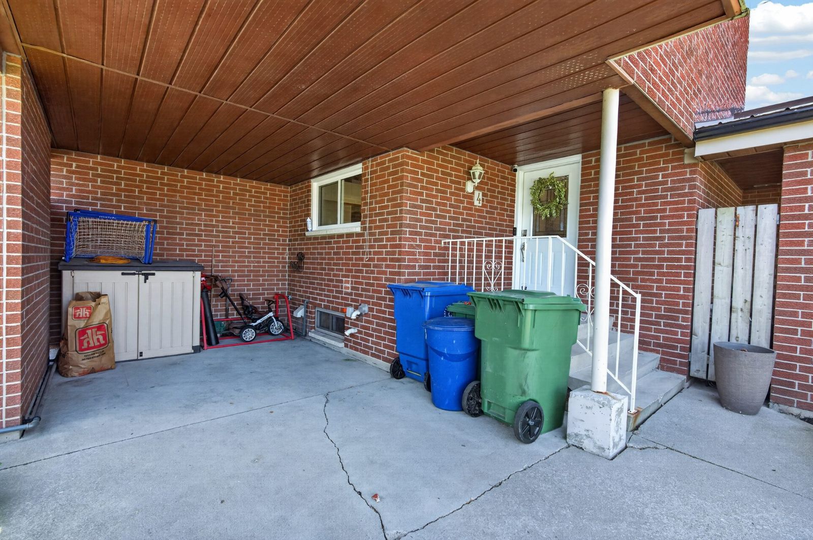 Covered front entrance porch with brick and white door