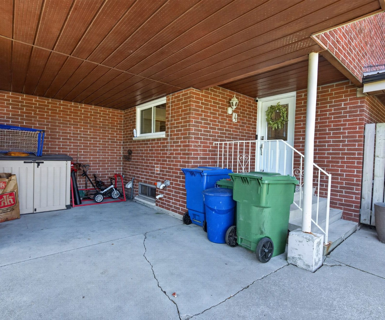 Covered front entrance porch with brick and white door