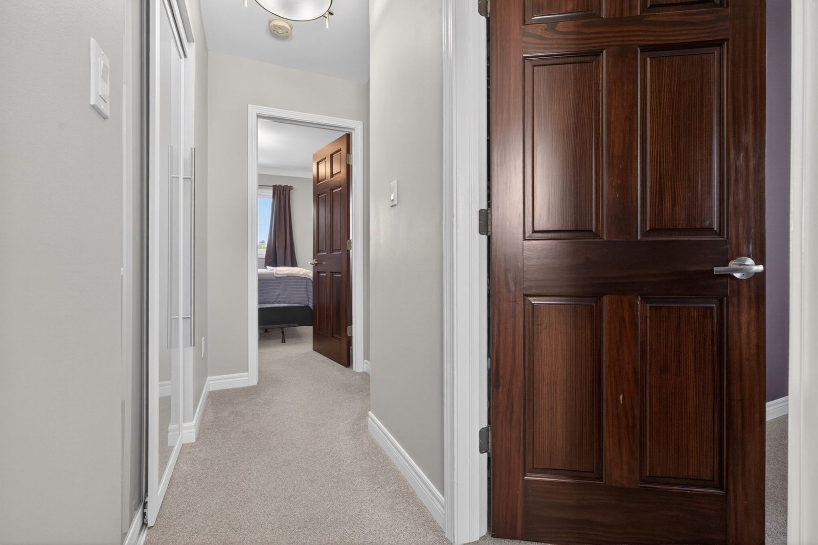 Upper hallway with frosted closet doors and ceiling light
