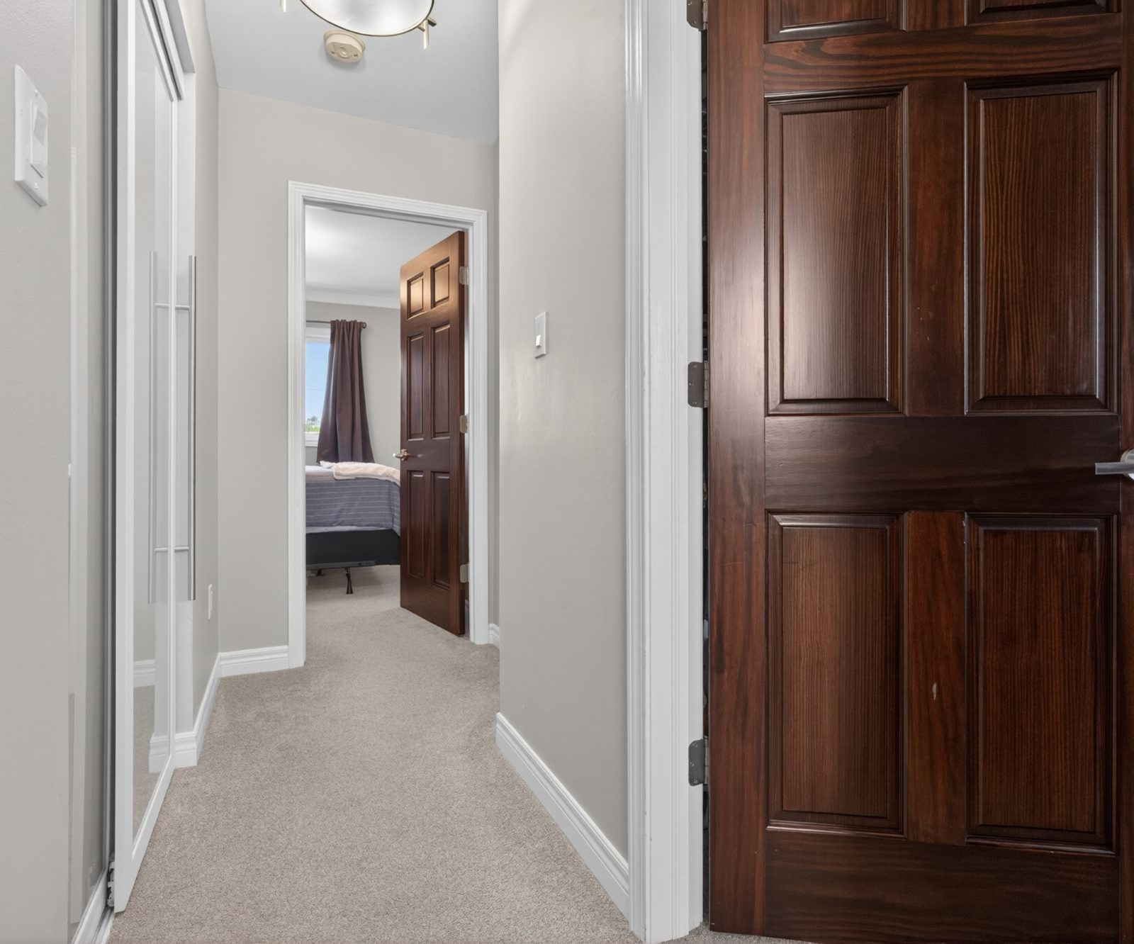 Upper hallway with frosted closet doors and ceiling light