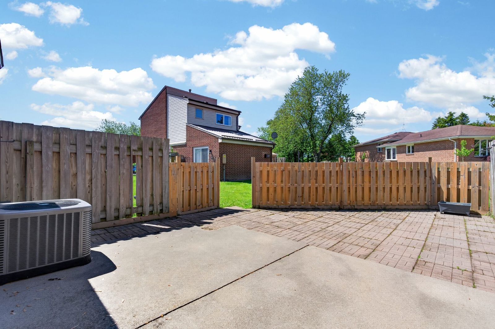 Fenced backyard with concrete patio and lawn