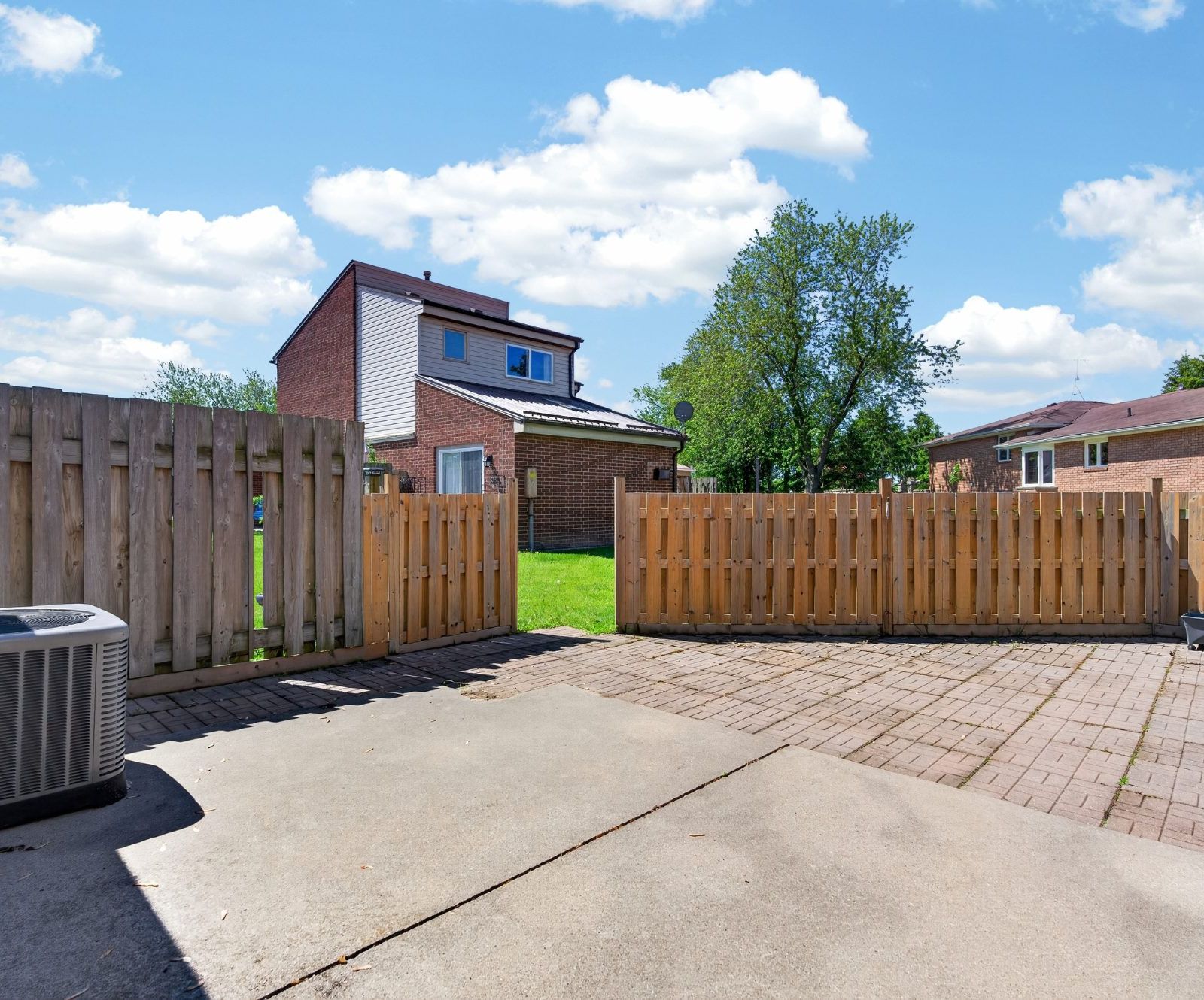 Fenced backyard with concrete patio and lawn