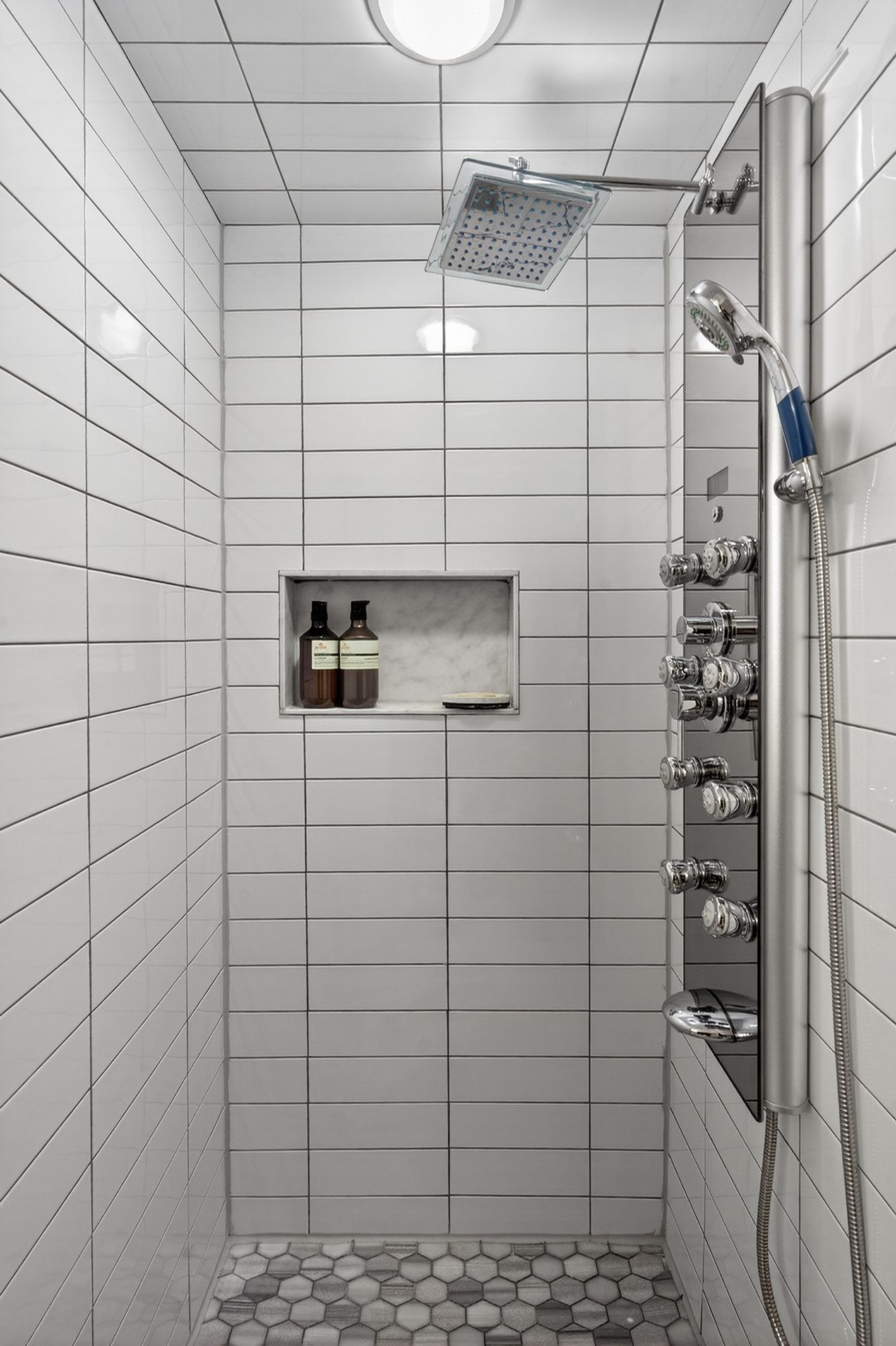 Bathroom shower with tiled walls and recessed shelf