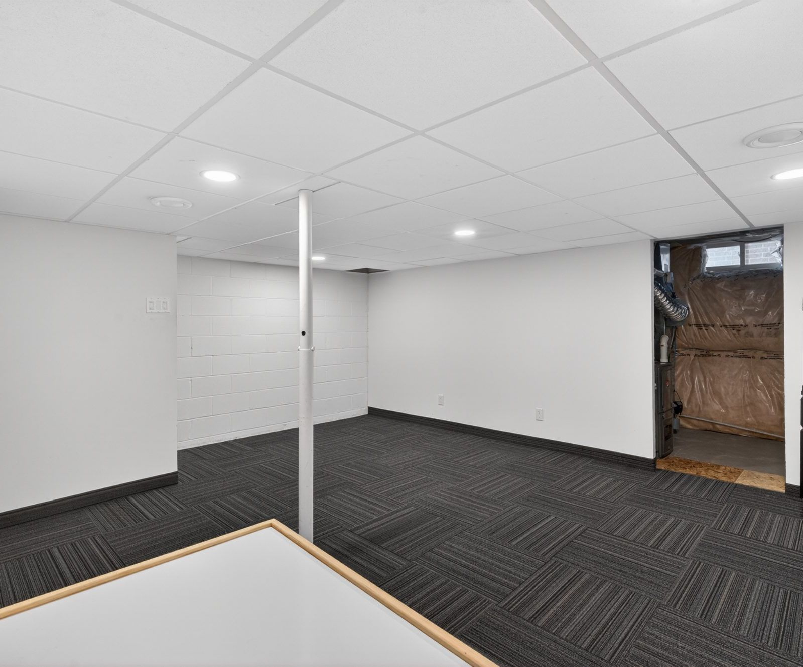 Basement open space with white walls and recessed lighting