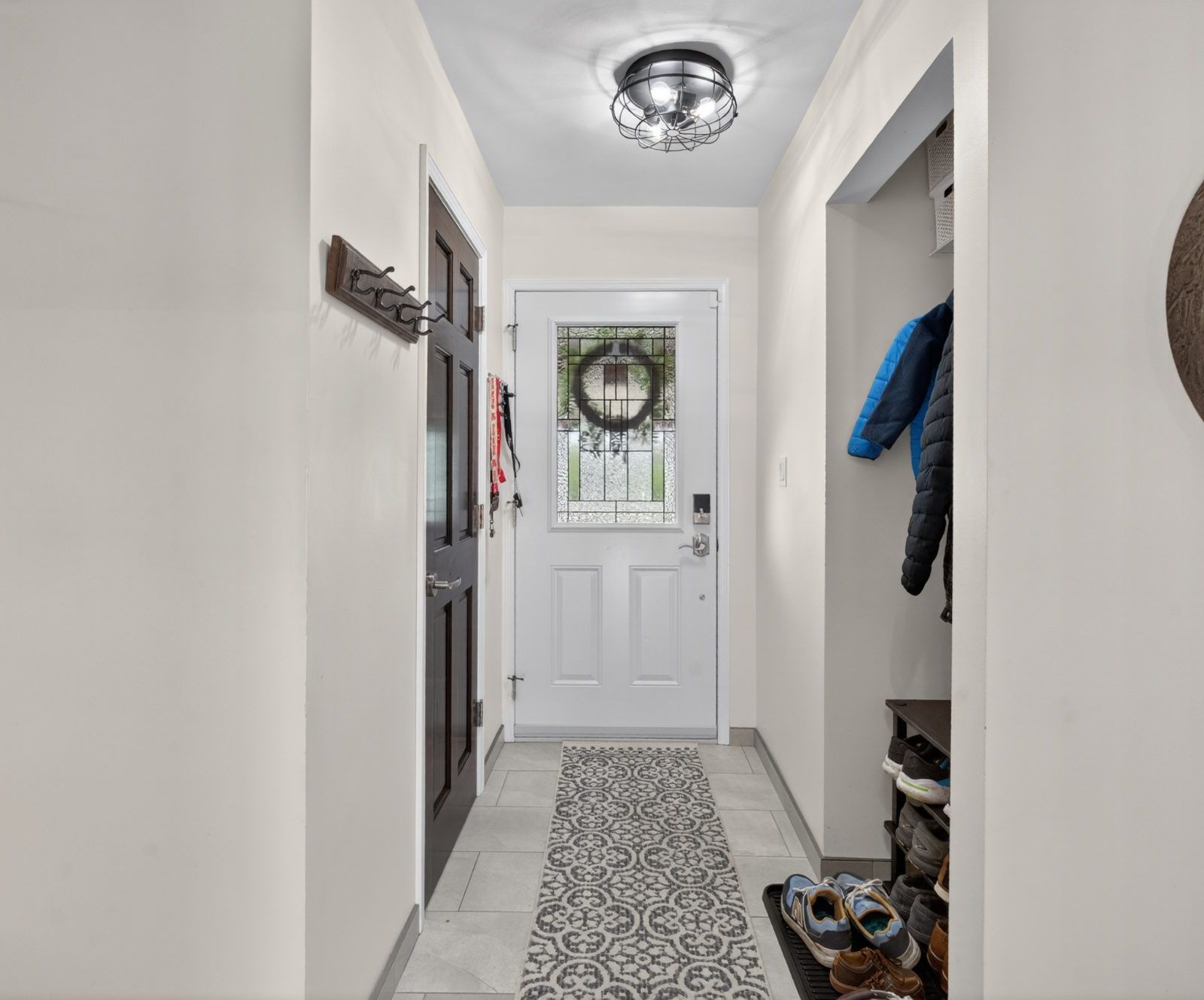 Entryway with patterned tile and coat closet