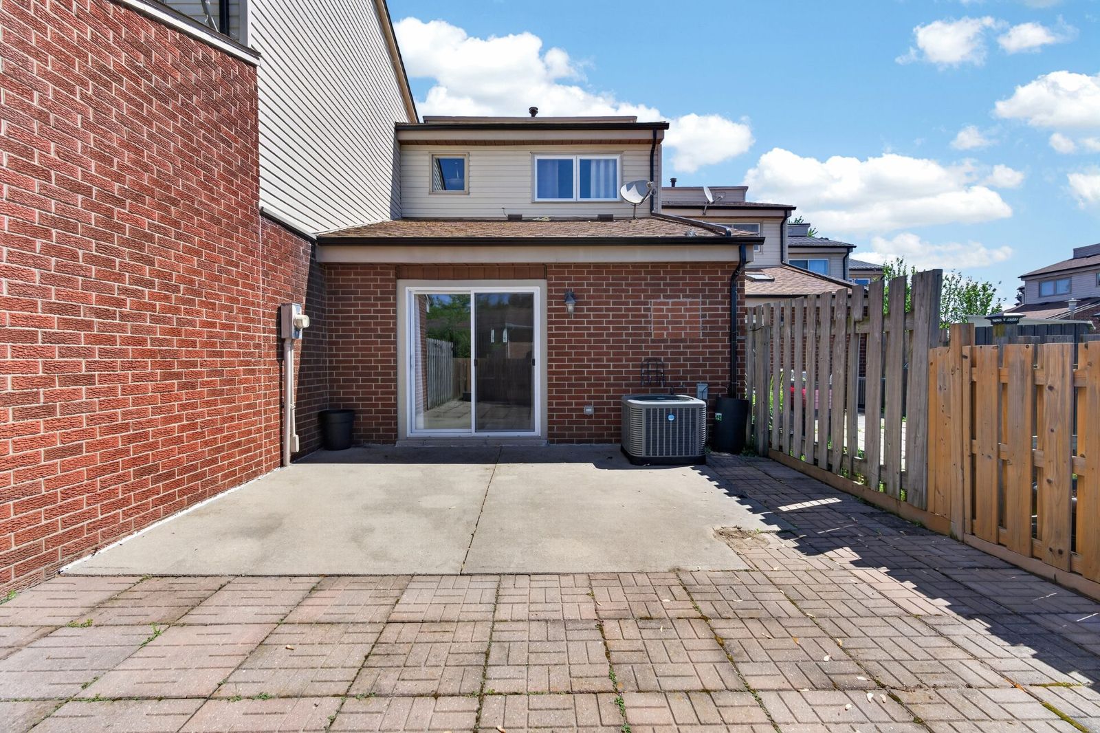 Rear exterior - brick, sliding glass door, concrete patio, fenced yard