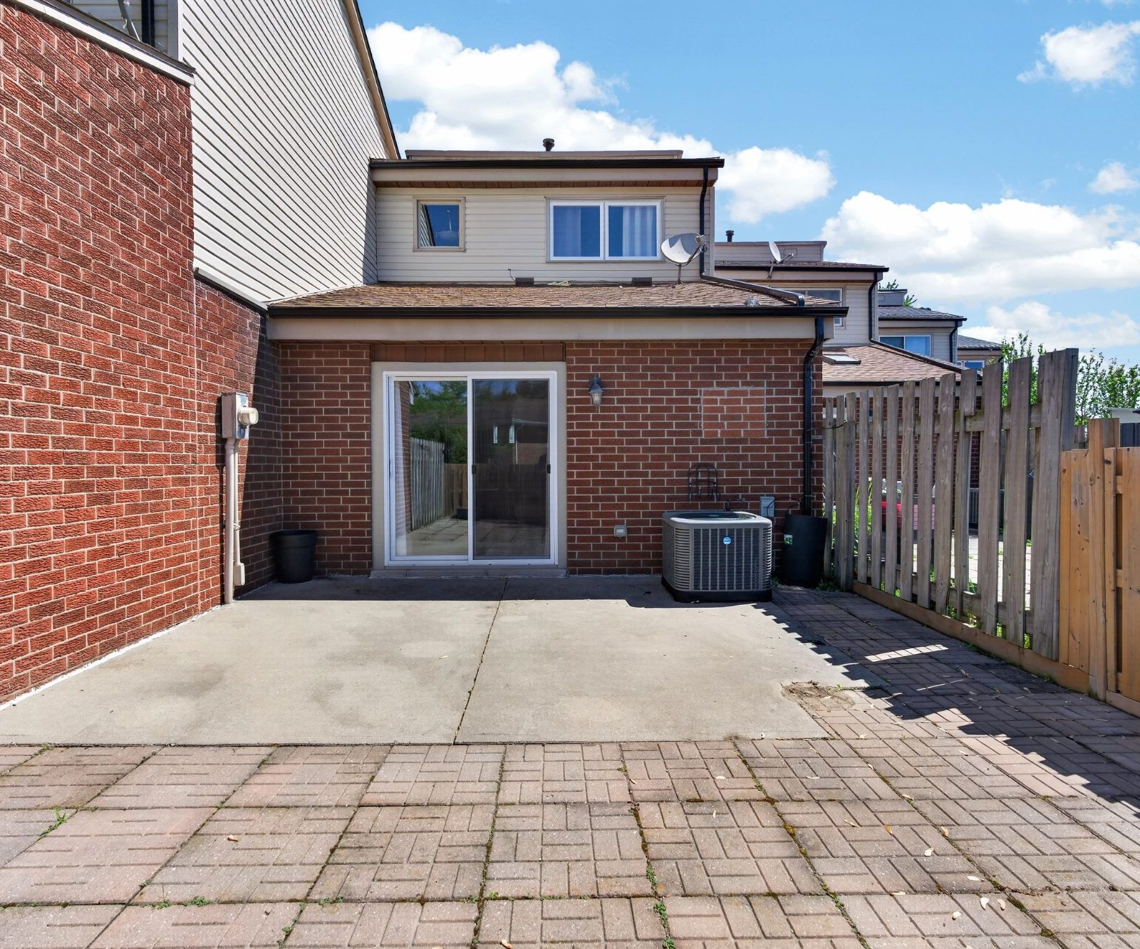 Rear exterior - brick, sliding glass door, concrete patio, fenced yard