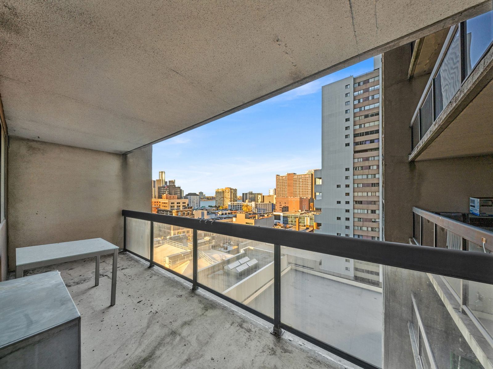 Covered balcony with glass railing and city skyline
