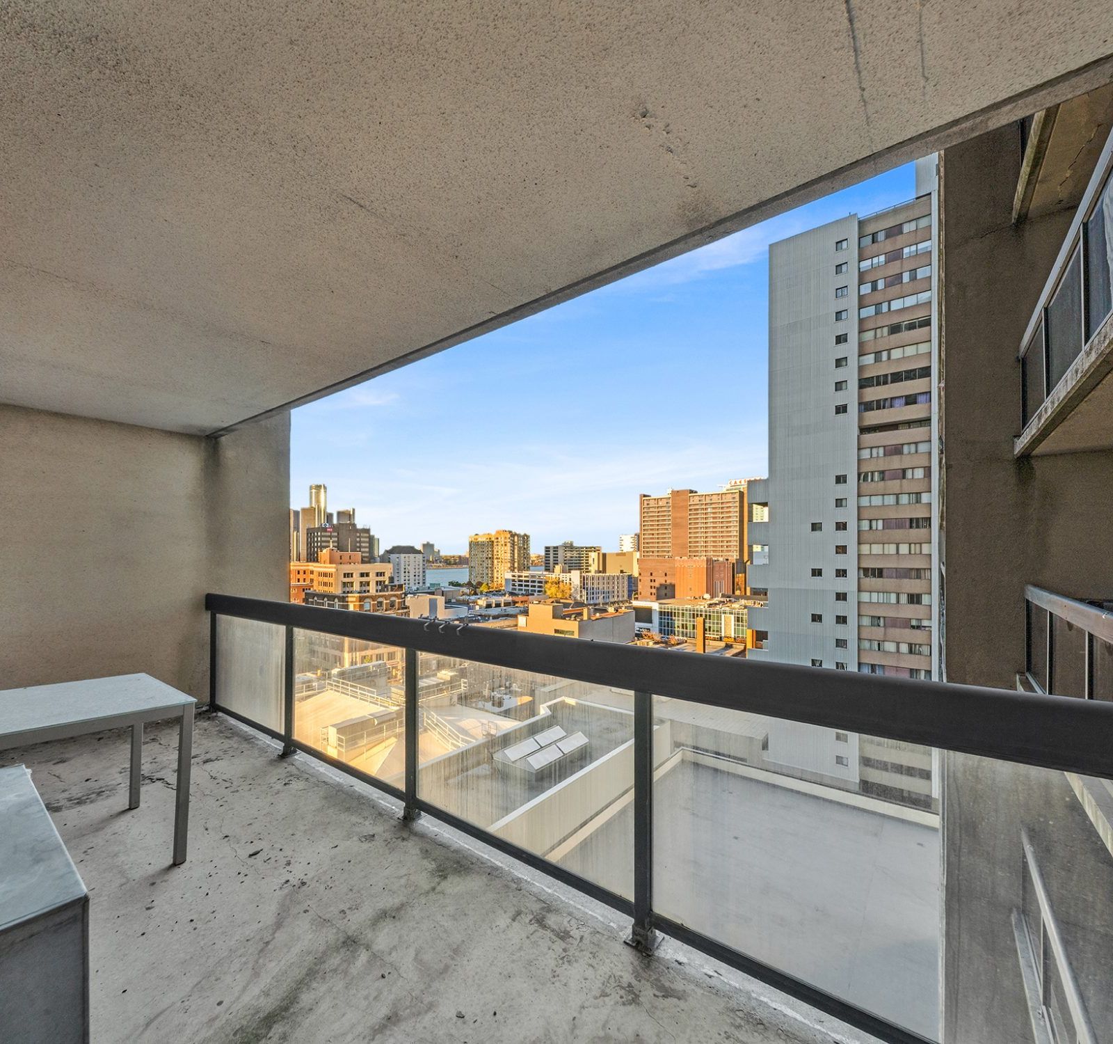 Covered balcony with glass railing and city skyline