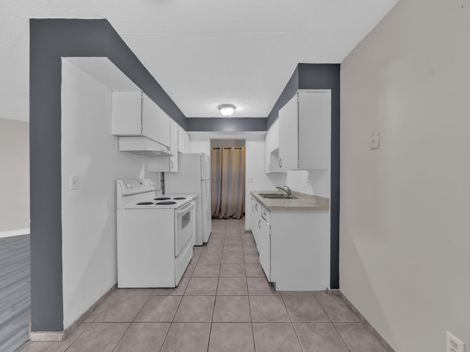 Kitchen with white cabinetry and tiled floor