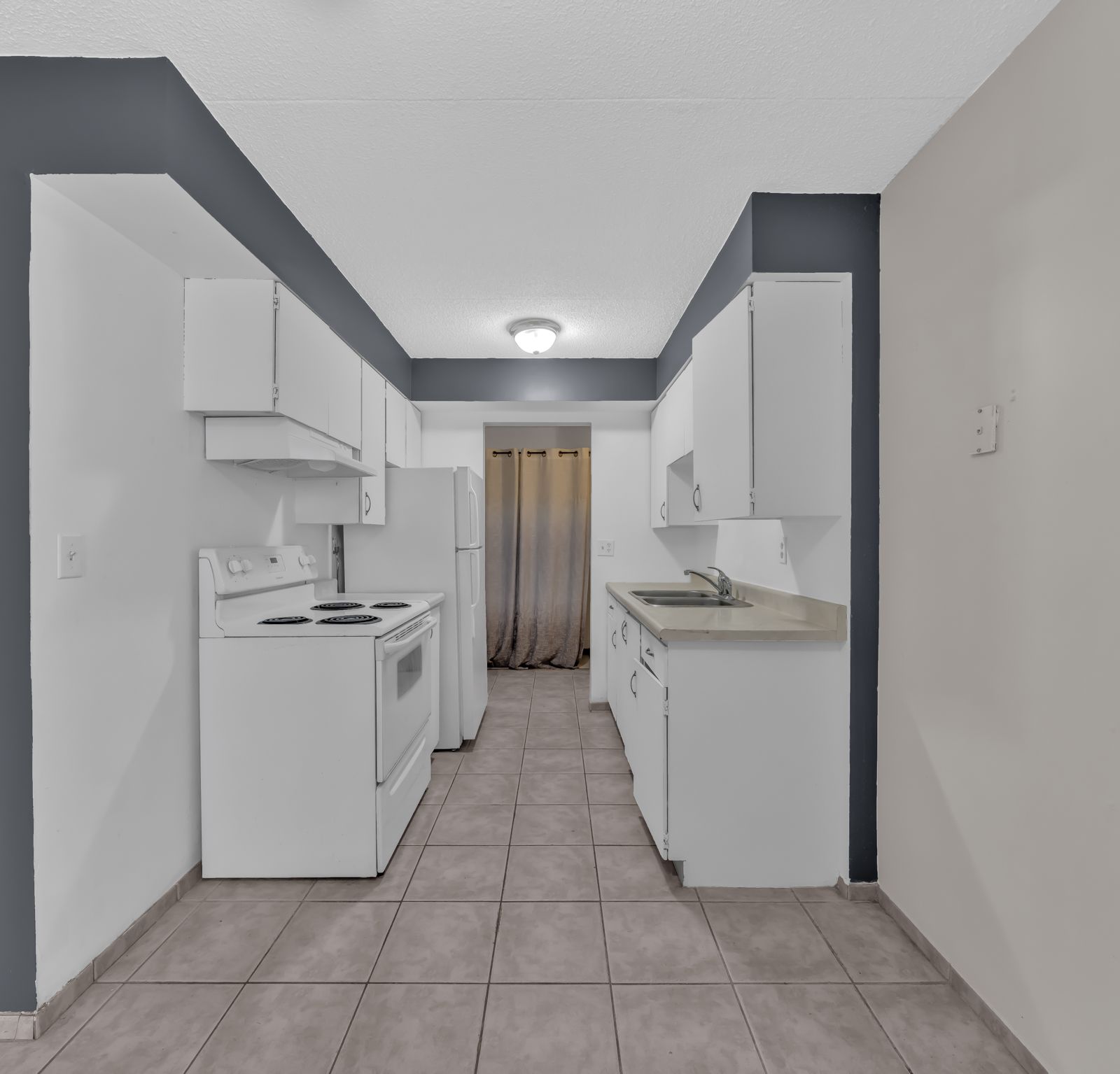 Kitchen with white cabinetry and tiled floor