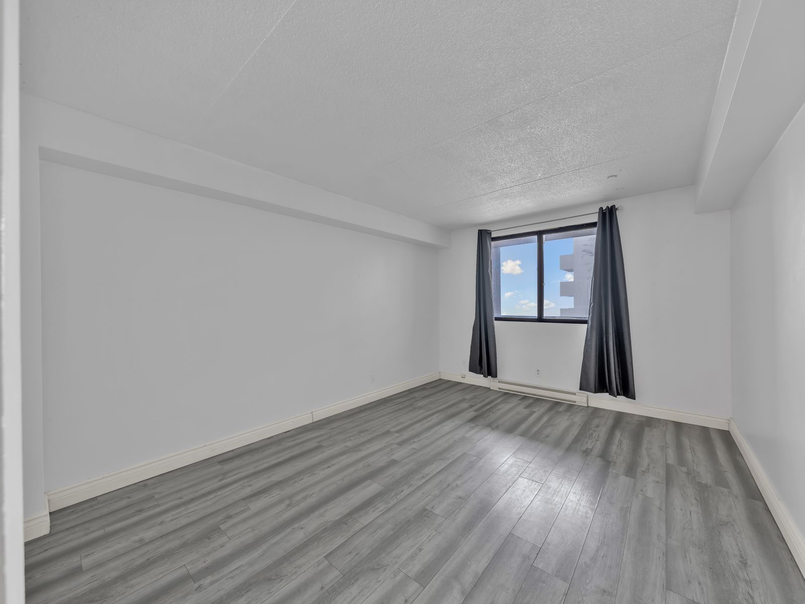 Bedroom with light grey wood flooring and window