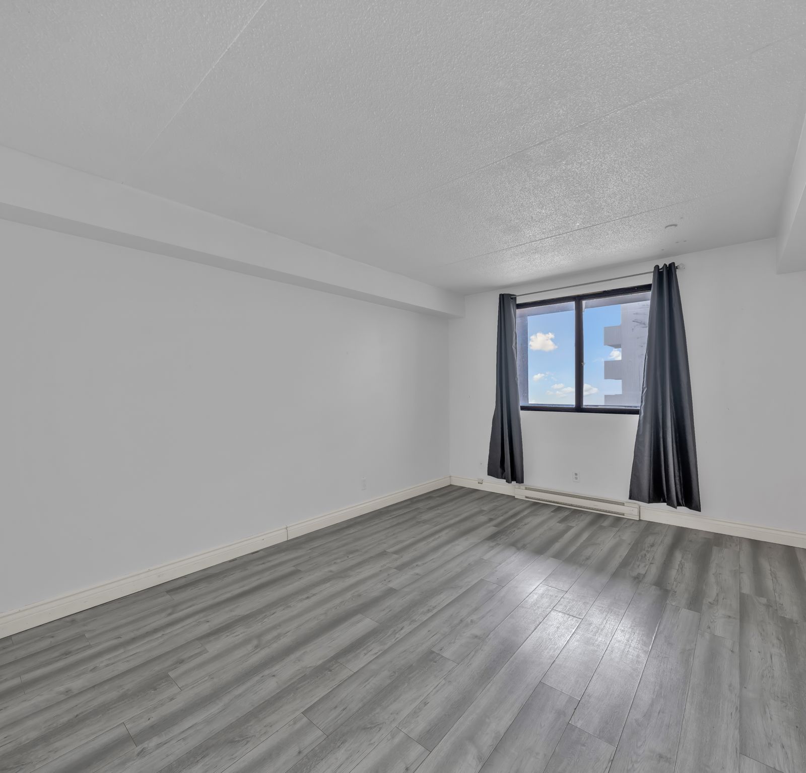 Bedroom with light grey wood flooring and window