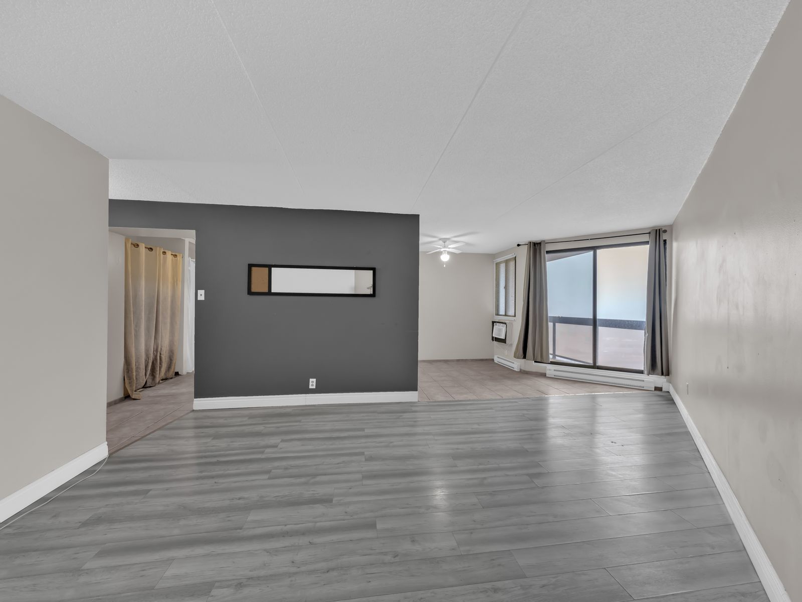 Living room with grey laminate flooring and sliding glass door