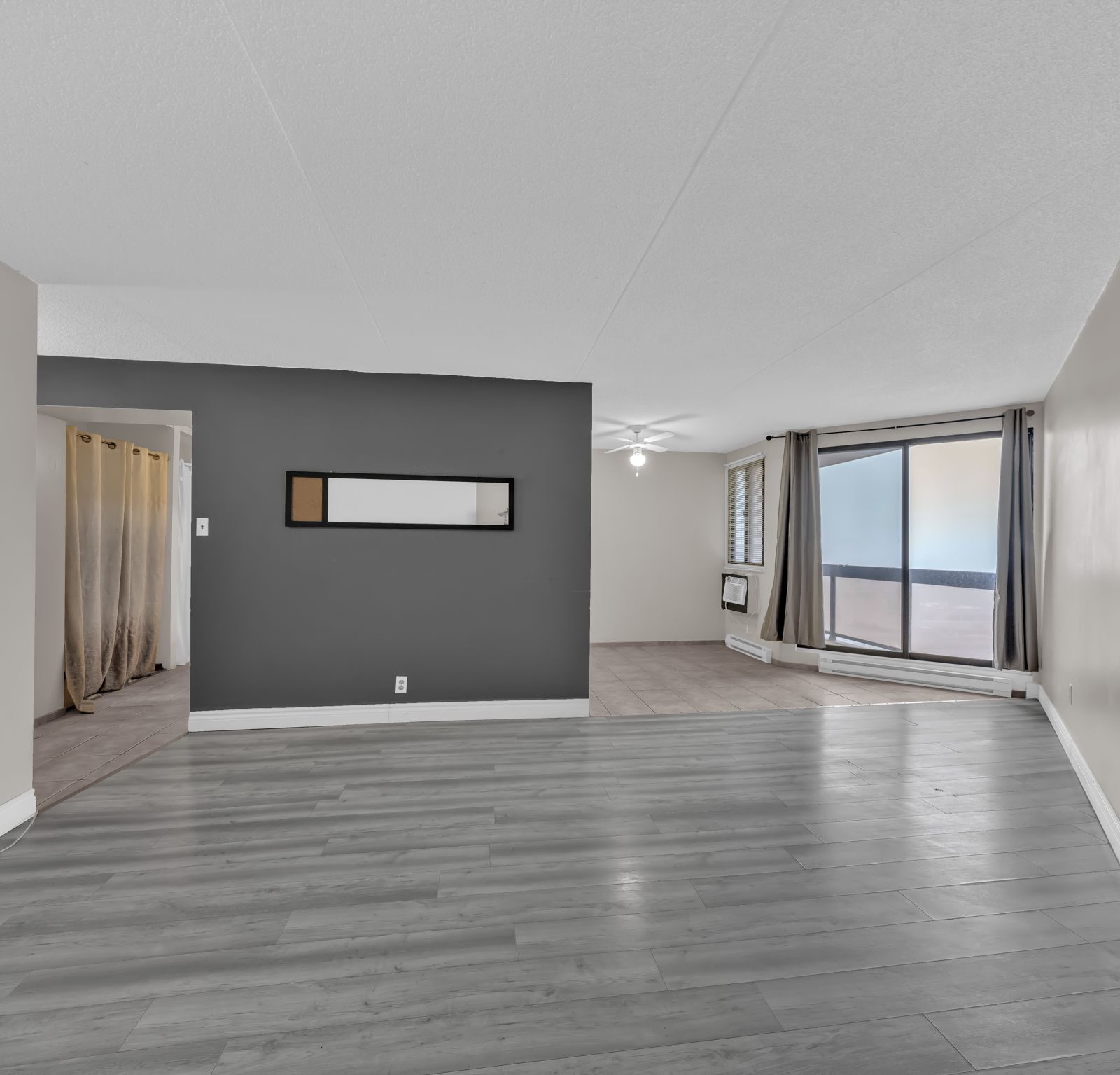 Living room with grey laminate flooring and sliding glass door