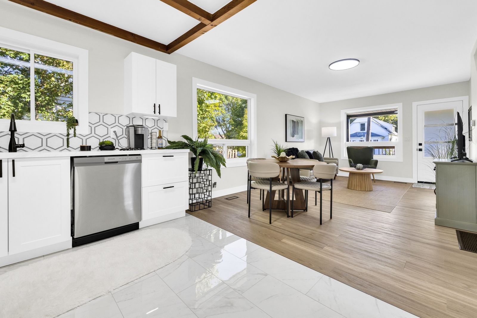 Kitchen counter and dishwasher, looking across the dining area to the living room and front door.