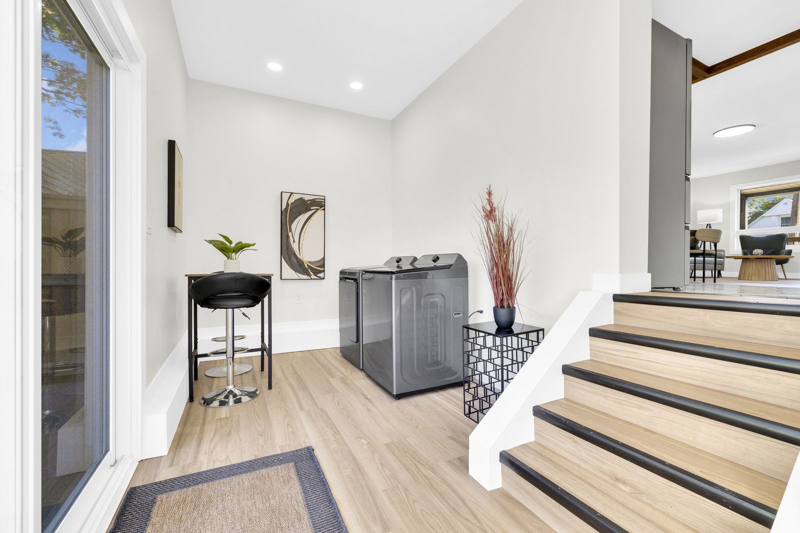 Back entry with the washer and dryer, a sliding glass door on the left and steps up to the main floor.