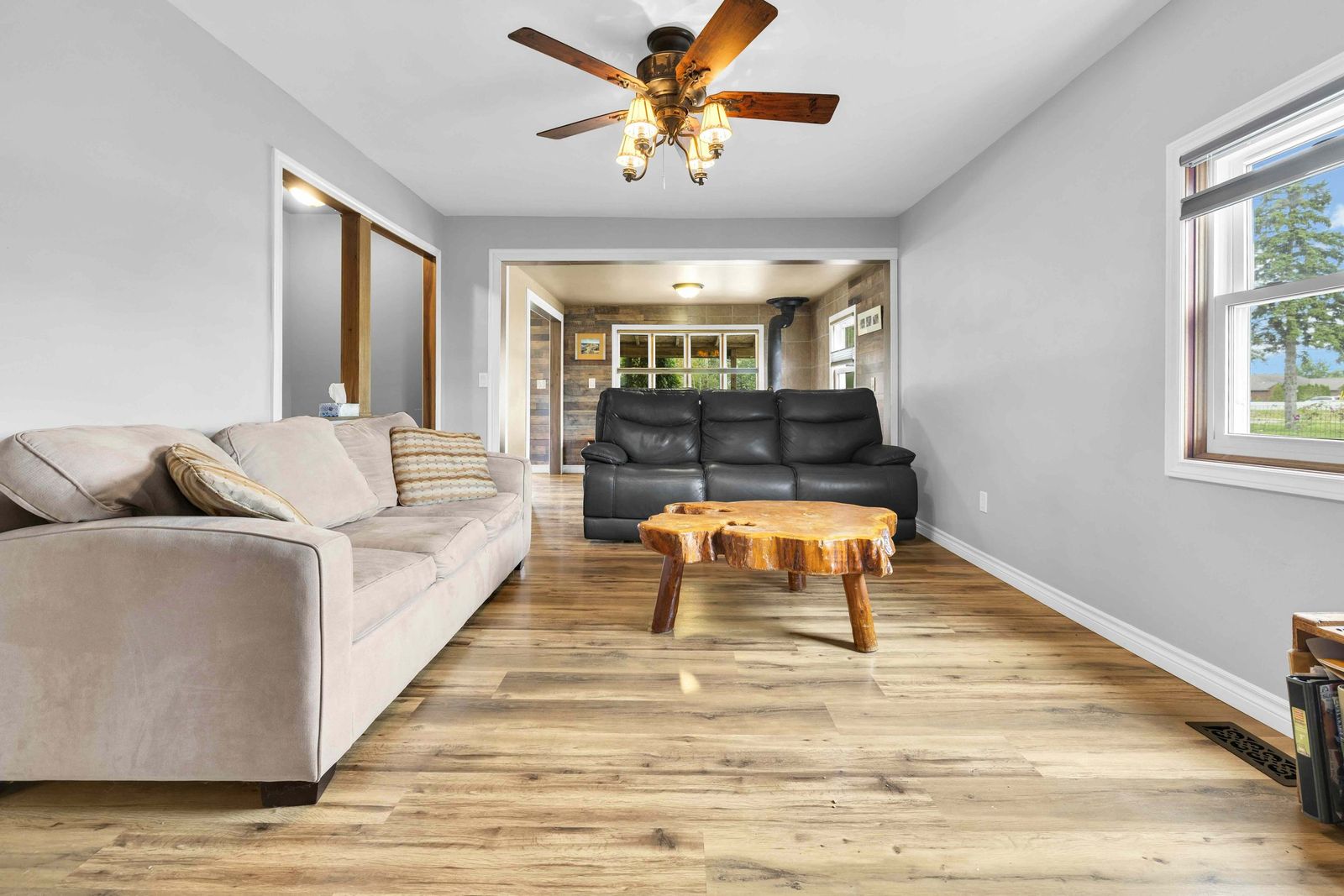 Living room with sofas, a wooden coffee table and a ceiling fan.