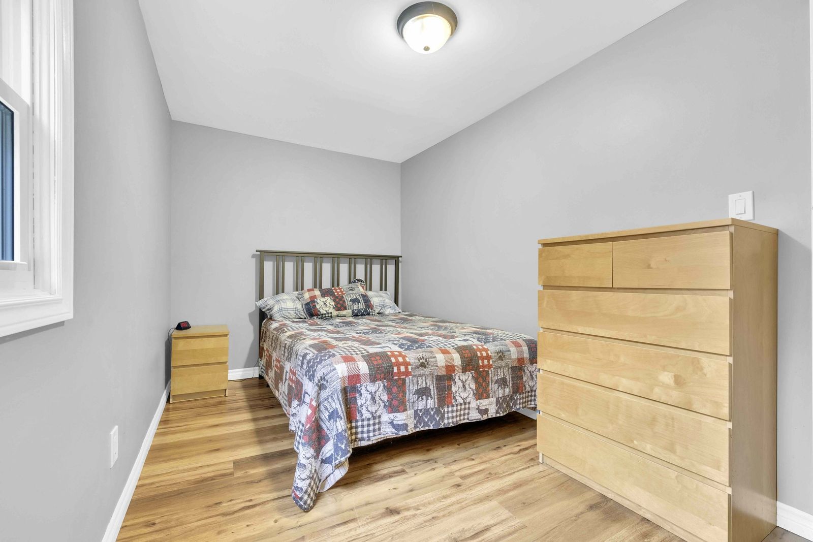 Bedroom with a full bed, dresser and nightstand.