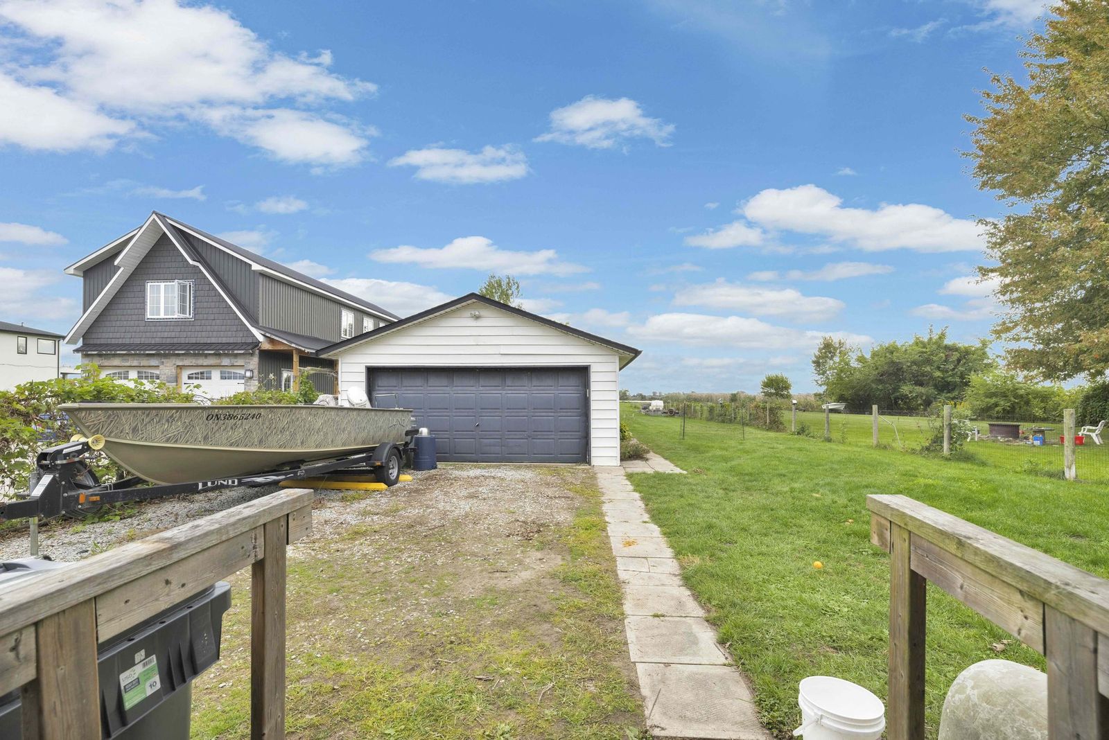 Driveway leading to the detached garage, with a boat on a trailer.