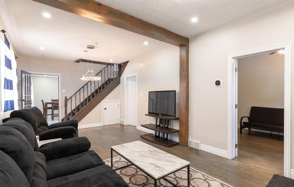 Living room with a sofa, a television and a wood beam across the ceiling.