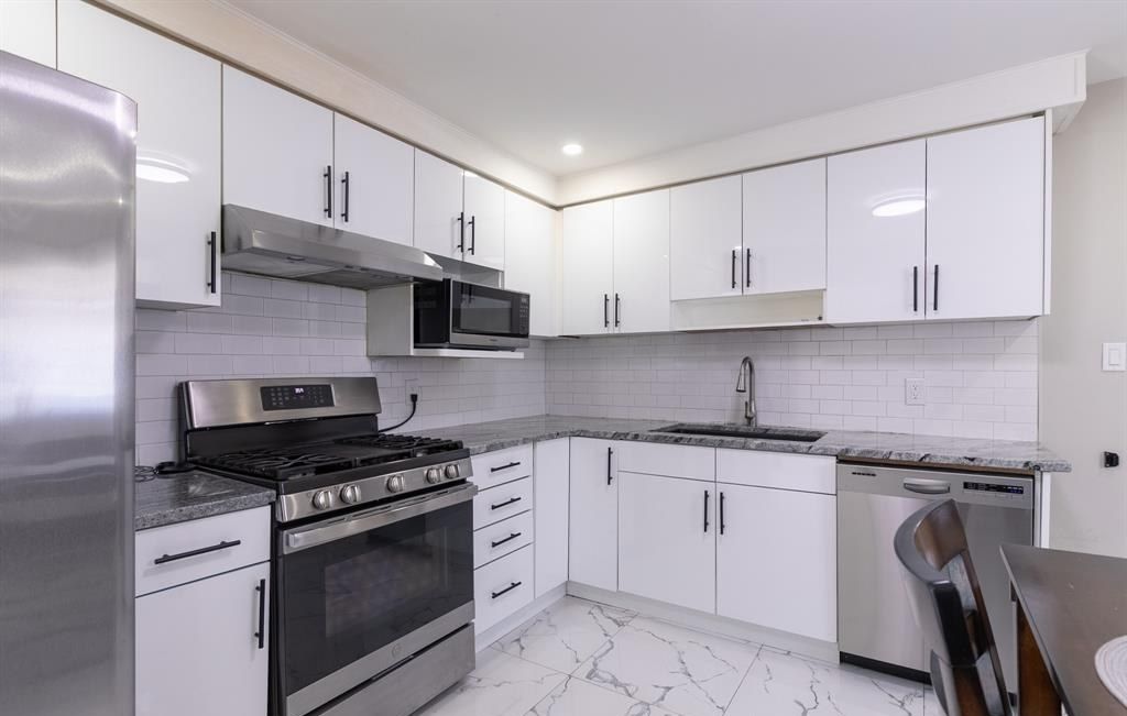 Kitchen with a refrigerator, a range, a microwave and a dishwasher.