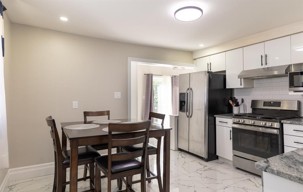 Kitchen with a dining table in the foreground and a window at the far end.