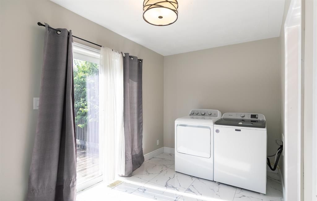 Washer and dryer beside a sliding glass door.
